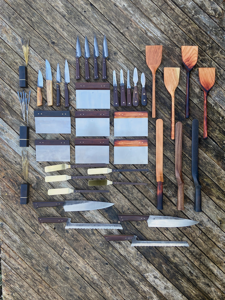 Product array overhead shot on deck, knives, spatulas, cocktail picks.