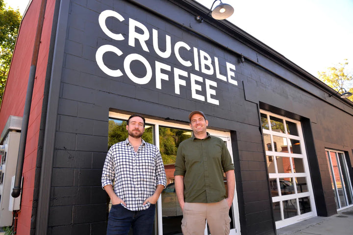 Crucible Coffee owners posing at store facade signage