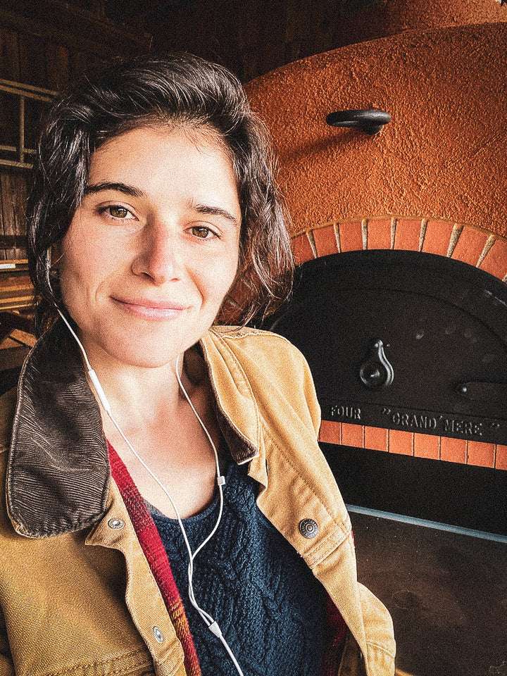 Portrait of Janey Giogiosa, baker and owner of Janey's Bread in front of wood fire oven