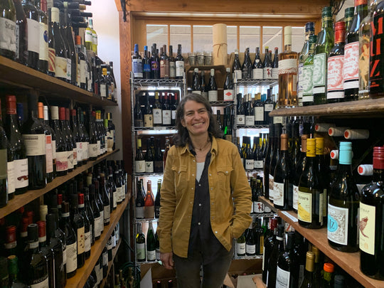 Portrait of Nina Atwell, owner of Greenwood Grocery, in wine aisle. 