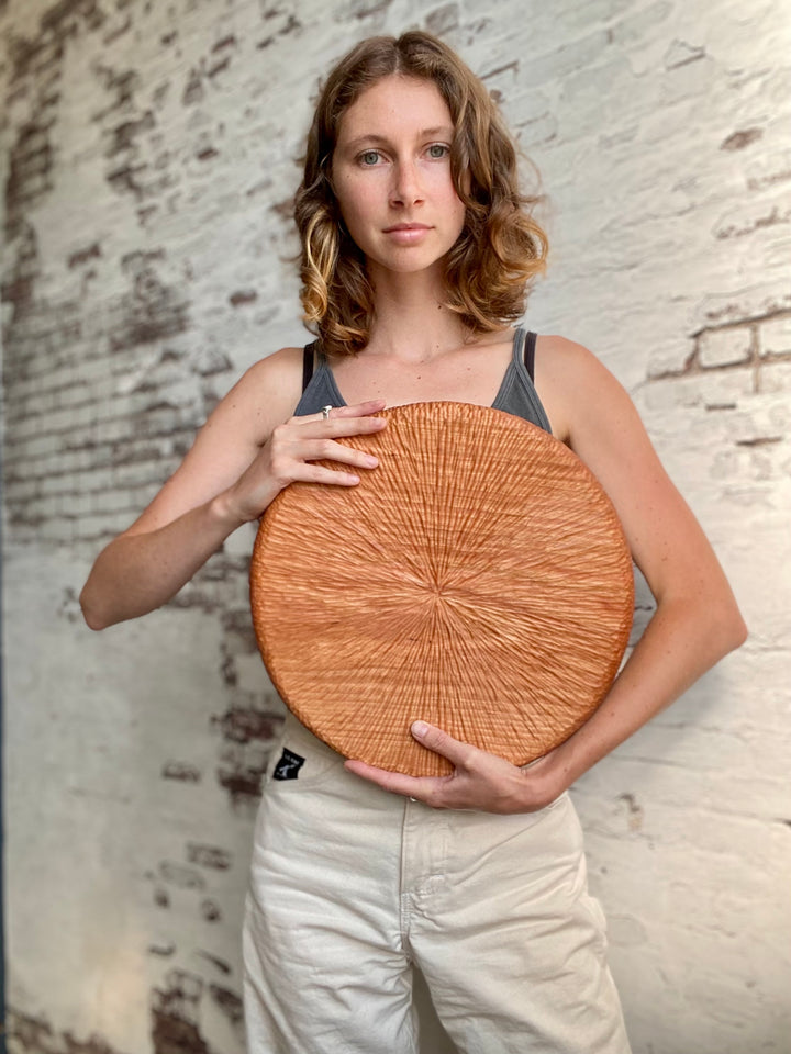 Portrait of Sarah Grace Cheek, woodworker holding seder plate.