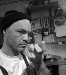 Portrait of Zack Sorrel, knifemaker at Monolith Knives, looking at edge of knife