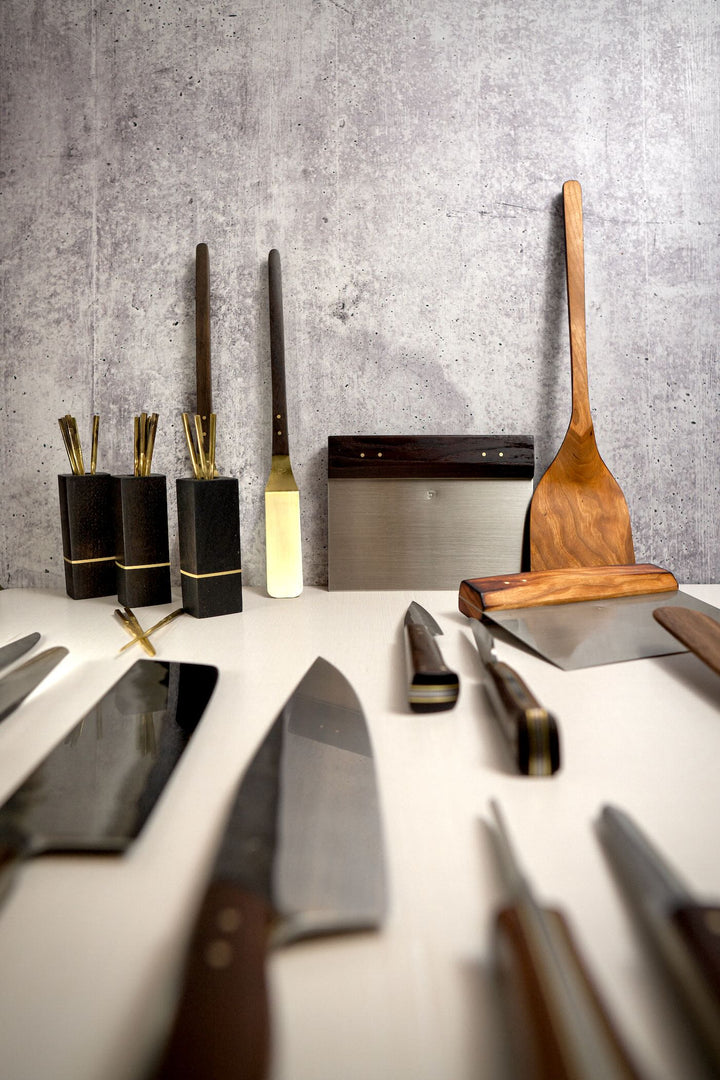 Product array portrait, knives, spatulas, neck knives, cocktail picks.