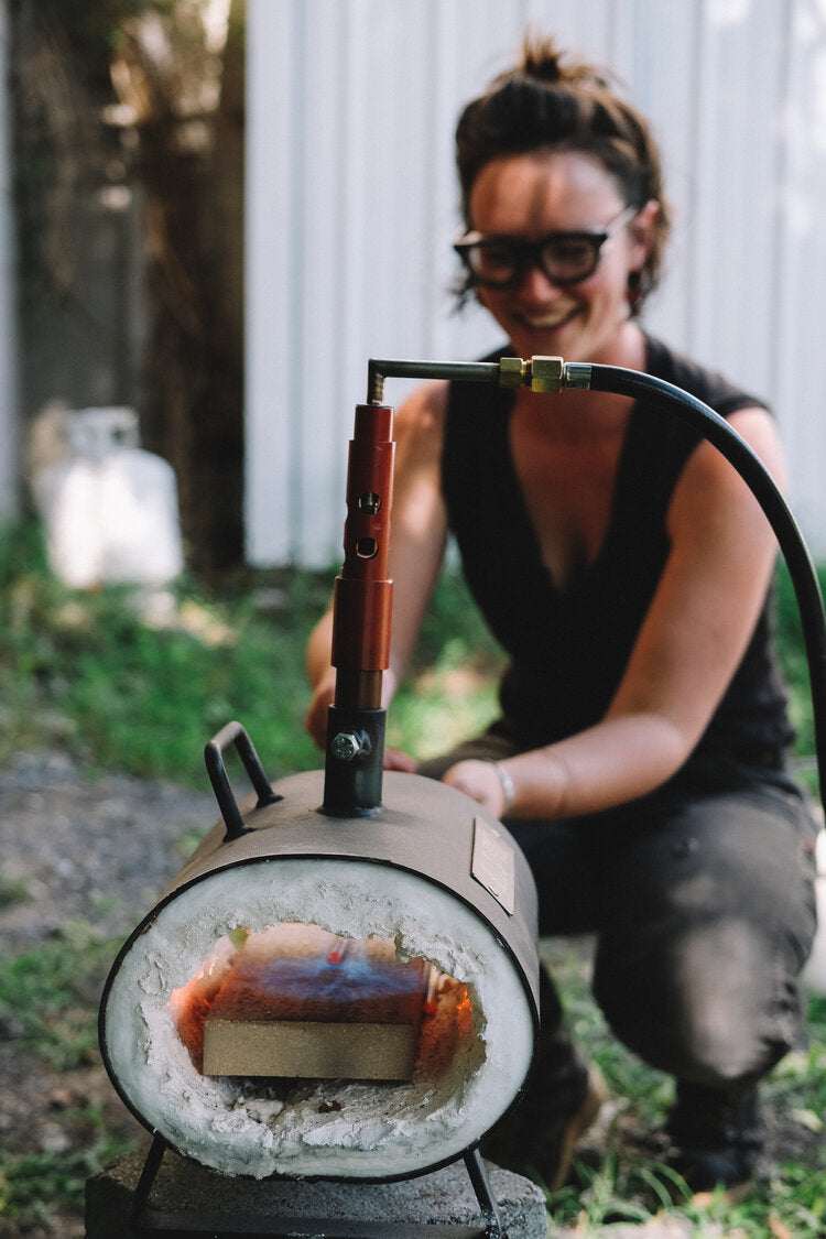 Portrait Of Molly Schermer, jewelry maker and blacksmith at Temper and True in front of forge