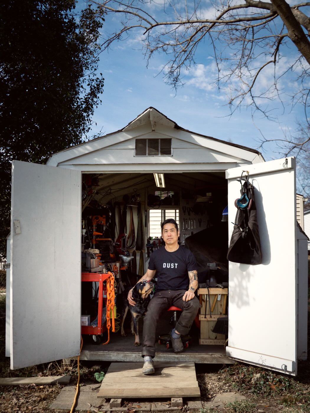 Dustworks team portrait seated at shed workshop with doors open